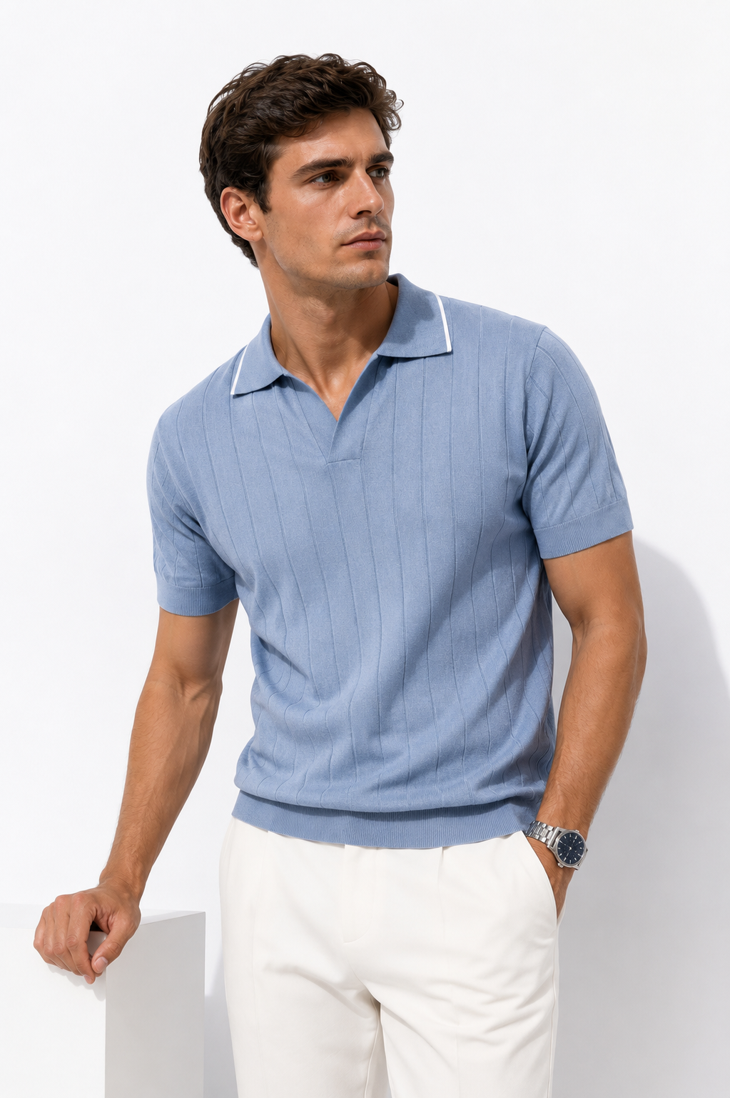 Light blue ribbed knit polo styled on male model against white studio background